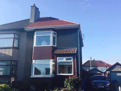House with red roof and bay window roofing