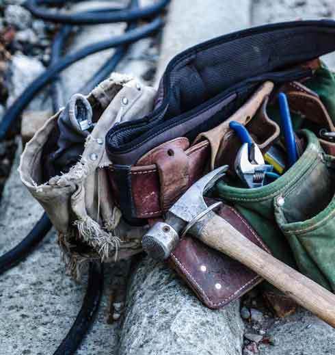 Toolbelt with hammer and spanner on a roof